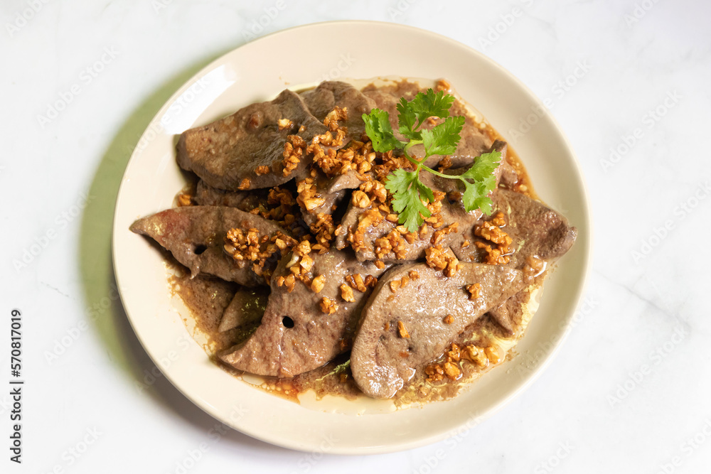 Fried pork liver with garlic on white plate. 