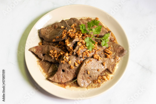 Fried pork liver with garlic on white plate. 