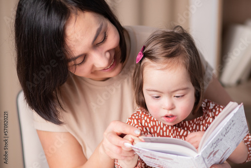International Down Syndrome Day, March 21, Mother and daughter reading a book