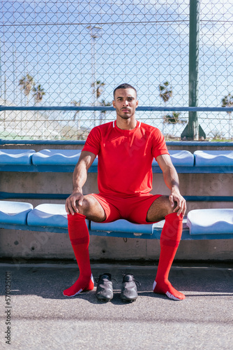 Portrait of African American male soccer player sitting on bench
