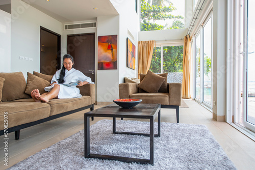 beautiful woman reading at living room of luxury villa in Phuket photo