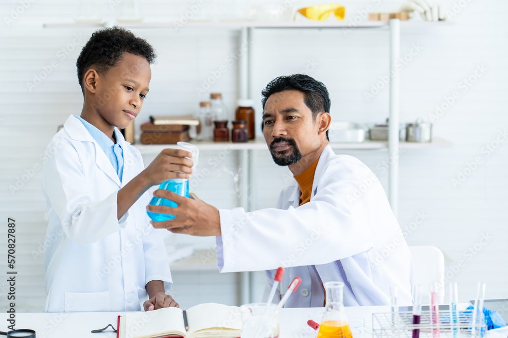 Asian male teacher teaches science, opens a laptop, lets a boy student of African descent look at a chemistry experiment. and have students take notes, read, and look at examples. Asian male teacher teaches science, opens a laptop, lets a boy student of African descent look at a chemistry experiment. and have students take notes, read, and look at examples.