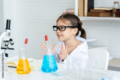 Adorable asian girl sitting in science room Learning science, doing real things, expressing joy who learned to do science experiments and wait to see the results with curiosity as a child