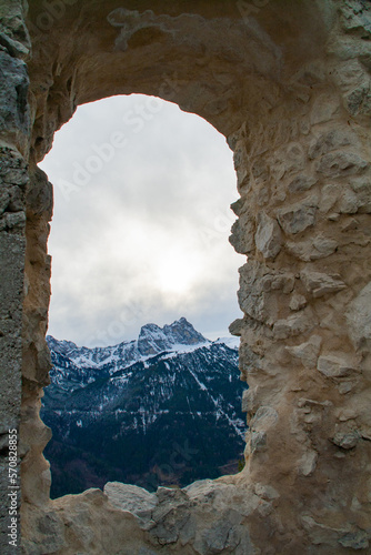 Fuessen, Germany - January 14th 2023 - Looking through a window of the Falkenstein ruin towards the Alps