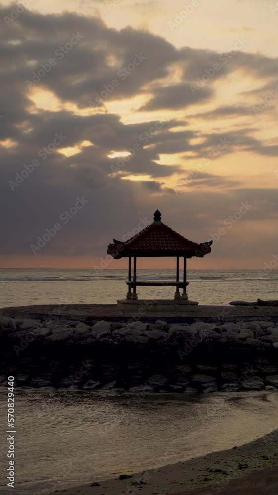 Handheld shot of silhouette gazebo at Sanur Beach against cloudy sky during sunset Handheld shot of silhouette gazebo at Sanur Beach against cloudy sky during sunset