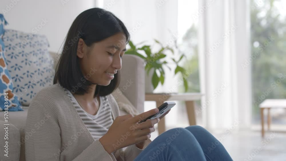 Side view. Asian teenager woman using smart phone or chat at home Side view. Asian teenager woman using smart phone or chat at home