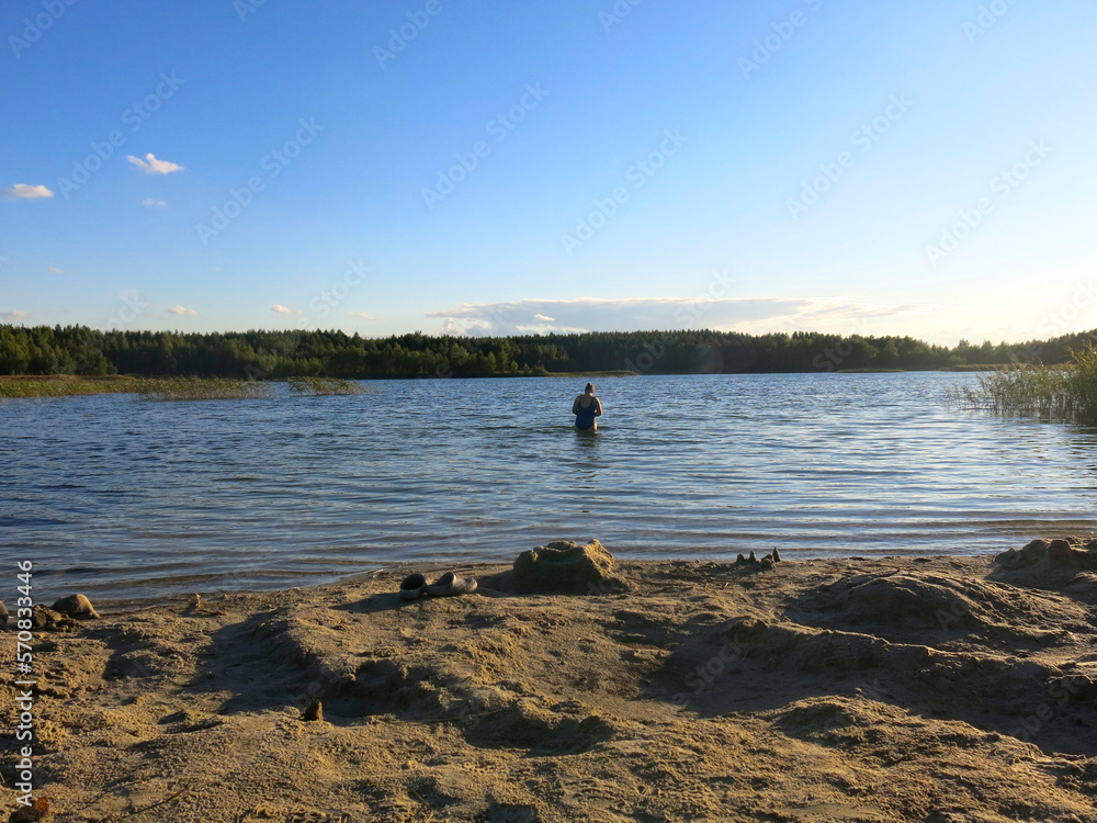 waters of a quiet lake with a sandy beach at sunset waters of a quiet lake with a sandy beach at sunset