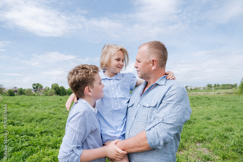 Mature man walking in nature with two children. Mature man walking in nature with two children.
