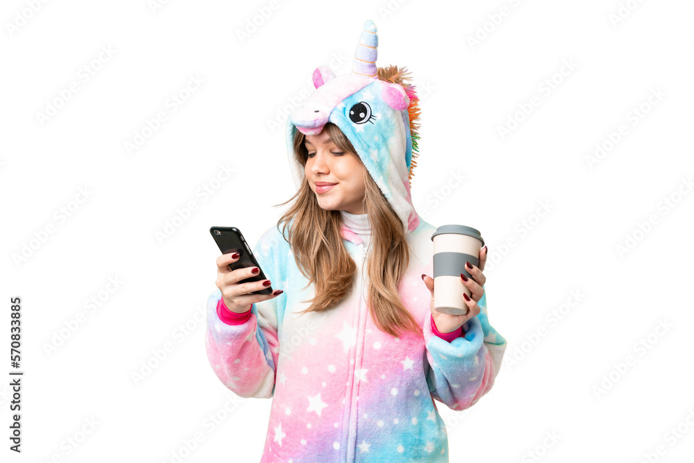 Young girl with unicorn pajamas over isolated chroma key background holding coffee to take away and a mobile Young girl with unicorn pajamas over isolated chroma key background holding coffee to take away and a mobile