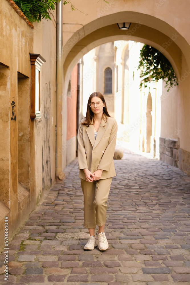 business woman in a light suit against the old summer city