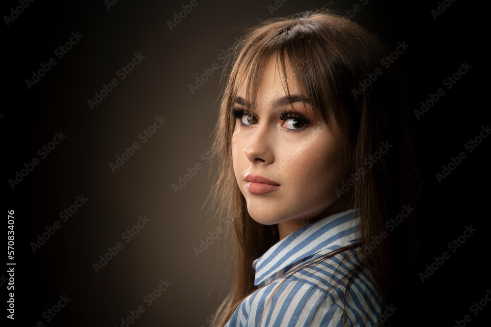 Young woman looking at camera isolated on dark background Young woman looking at camera isolated on dark background