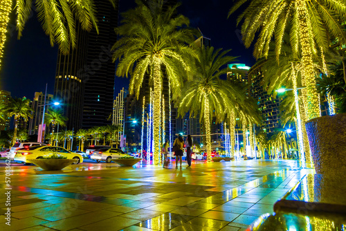 City center sidewalks in night light. Palm trees decorated with shining garlands. Empty city streets. © vladimircaribb