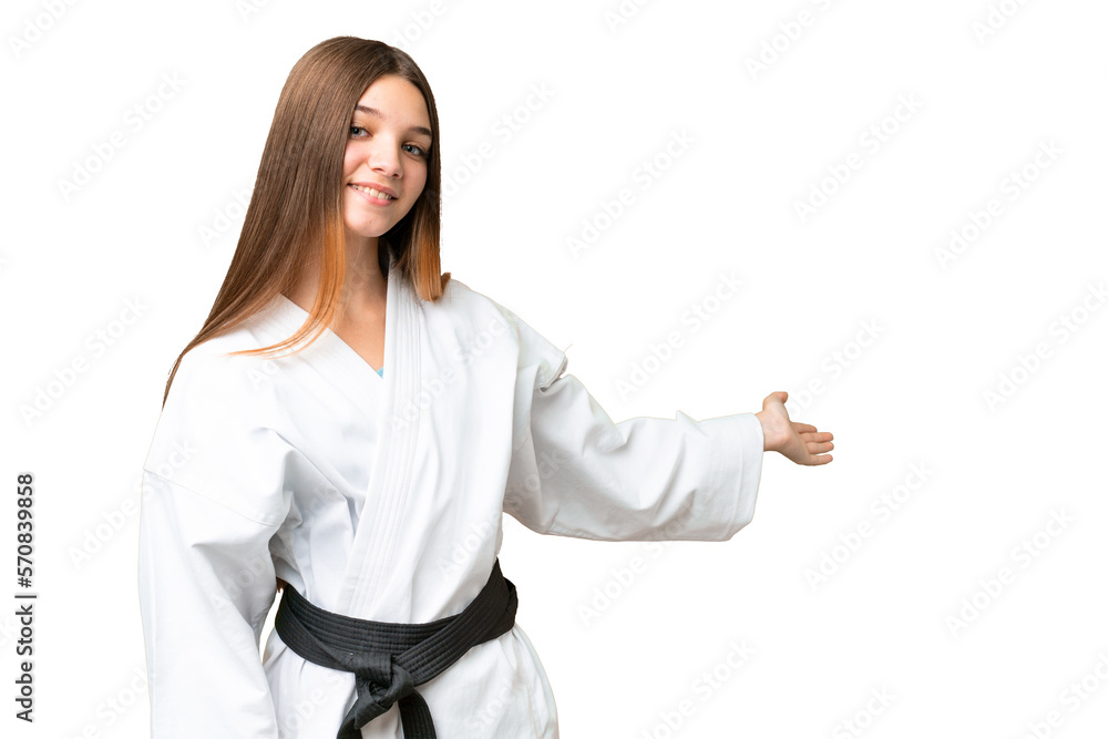 Teenager girl doing karate over isolated chroma key background extending hands to the side for inviting to come Teenager girl doing karate over isolated chroma key background extending hands to the side for inviting to come