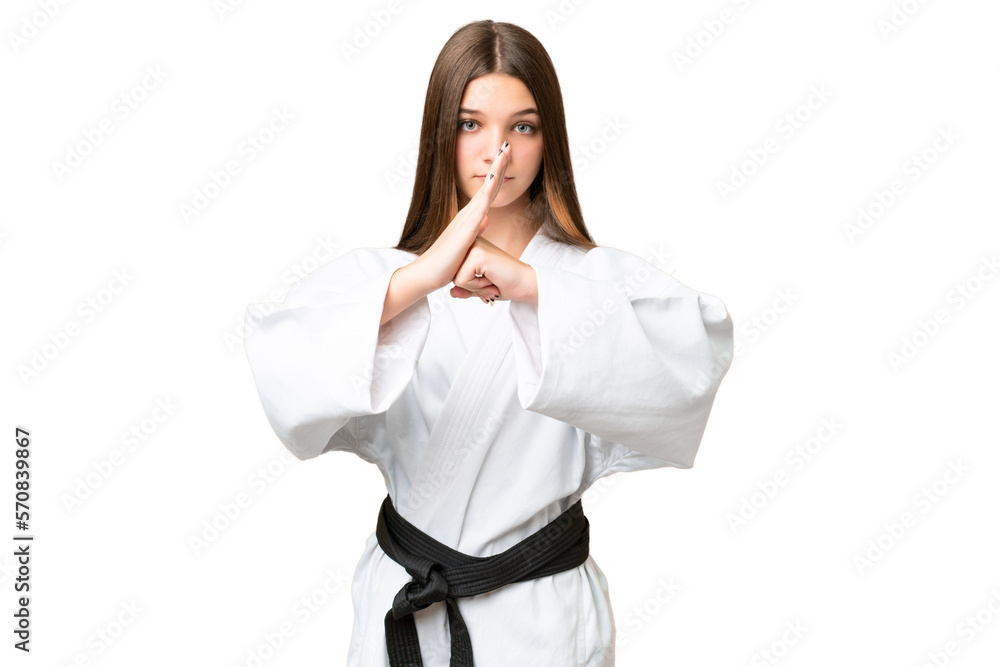 Teenager girl over isolated chroma key background doing karate and saluting Teenager girl over isolated chroma key background doing karate and saluting