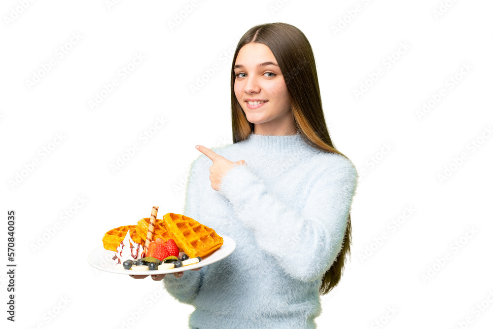 Teenager girl holding waffles over isolated chroma key background pointing back Teenager girl holding waffles over isolated chroma key background pointing back