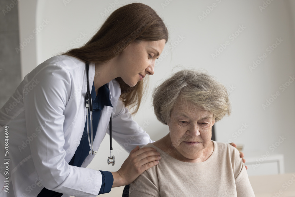 Sympathetic geriatrician embracing serious lost elderly patient with support, care, touching shoulders, giving comfort to woman with healthcare, memory problems, mental disorder Sympathetic geriatrician embracing serious lost elderly patient with support, care, touching shoulders, giving comfort to woman with healthcare, memory problems, mental disorder