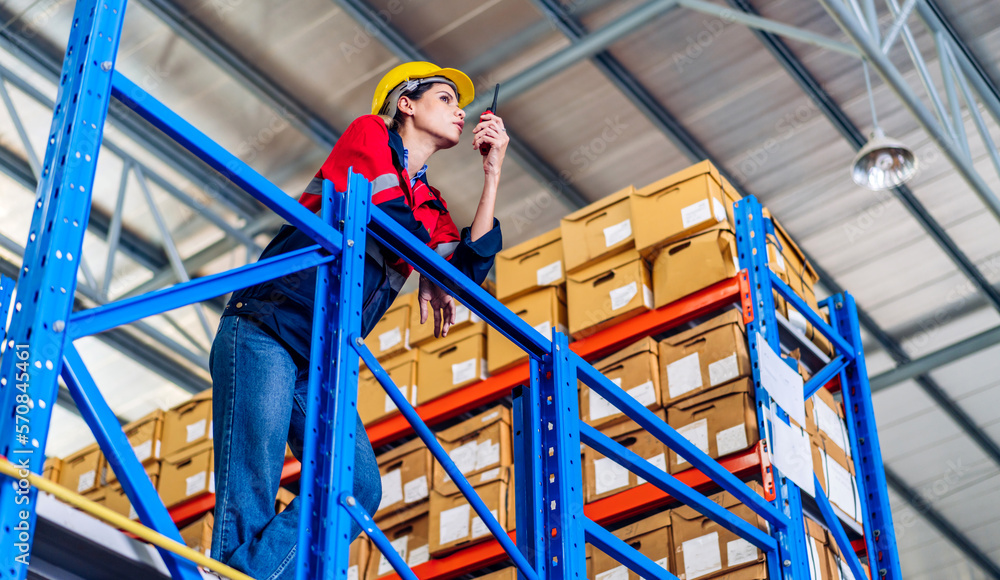 Portrait engineer woman shipping order detail check goods and supplies on shelves with goods background inventory in factory warehouse.logistic industry and business export