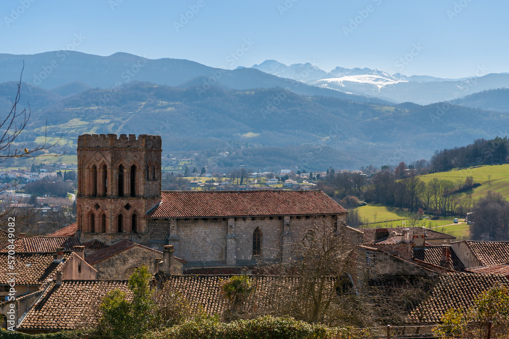 Saint-Lizier Cathedral in Saint-Lizier is a Roman Catholic cathedral, and the Pyrenees in the background, in Ariège, Occitanie, France