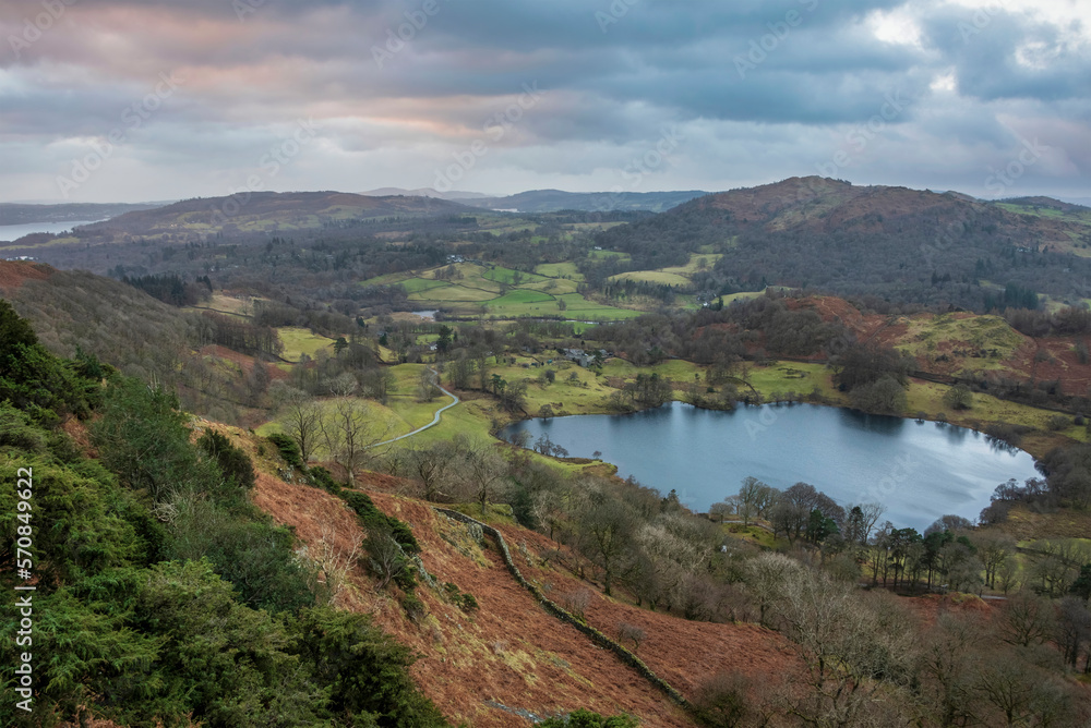 Stunning colorful Winter sunrise golden hour landscape view from Loughrigg Fell across the countryside in the Lake District