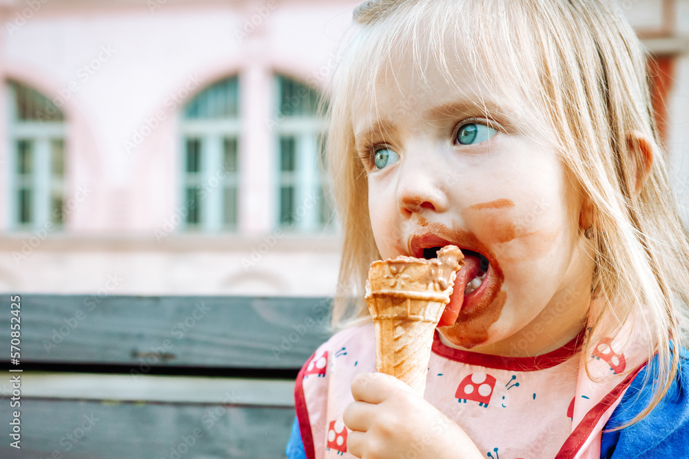 Cute little girl eating chocolate ice cream outdoors Stock Photo