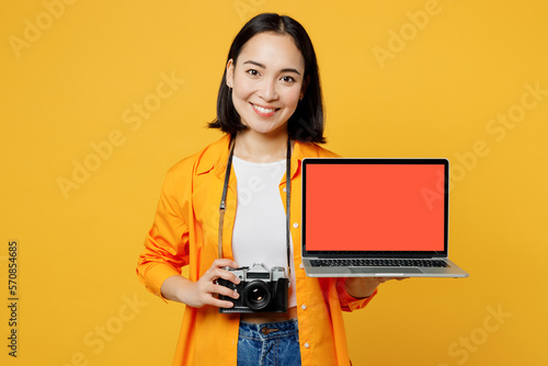 Young IT woman wear casual clothes hold use work on blank screen laptop pc computer isolated on plain yellow background Tourist travel abroad in free time rest getaway Air flight trip journey concept #570854685