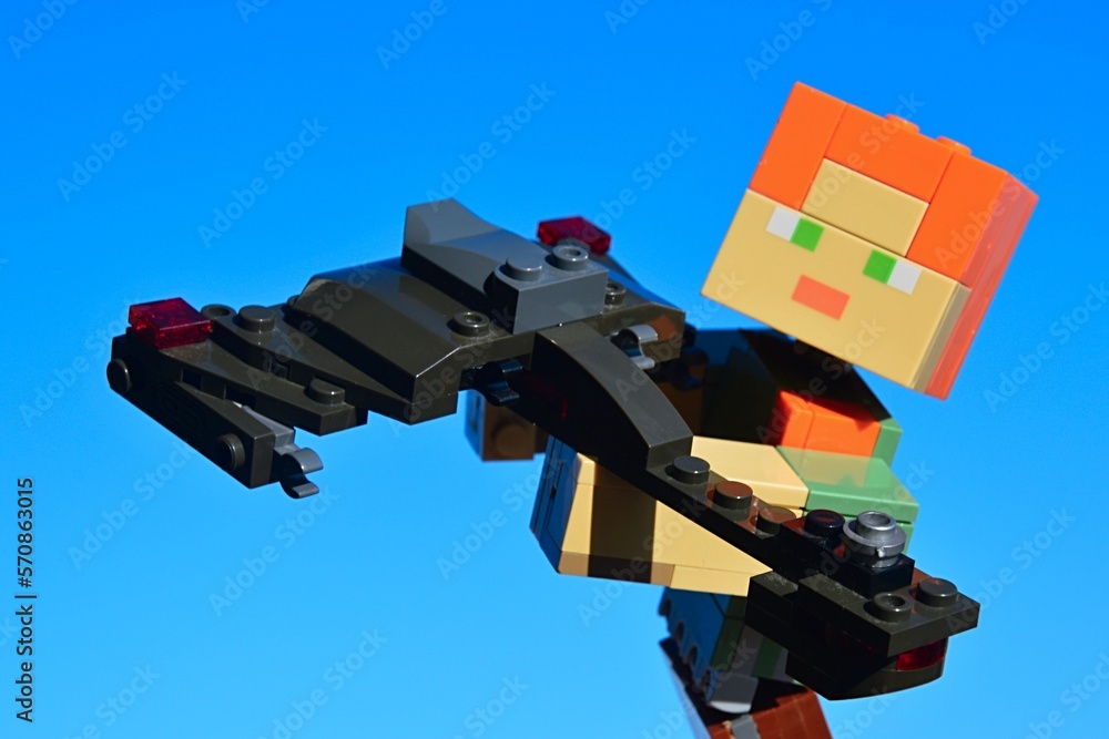 Obraz premium LEGO Minecraft large figure of main character Alex is examining model of Klingon battleship Bird Of Prey from Star Wars TV and movie franchise, made by KREO. Clear winter day, blue skies in background