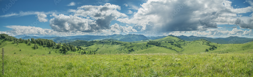 Panoramic view of a summer day in the mountains, green meadows, mountain slopes and hills, countryside