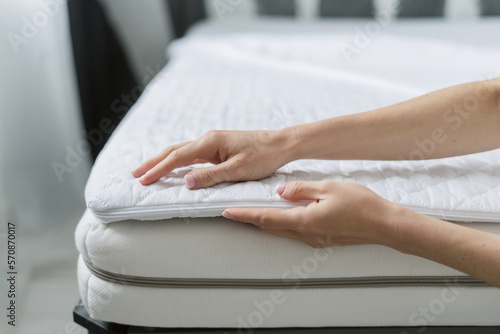 Fototapeta woman select new mattress cover in furniture store, closeup