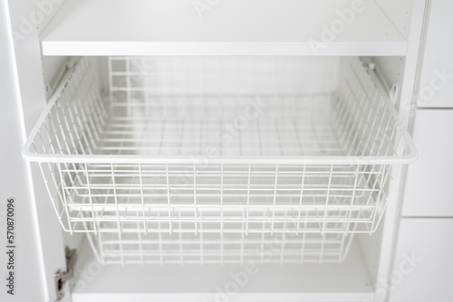 metal white baskets inside wood wardrobe, closeup