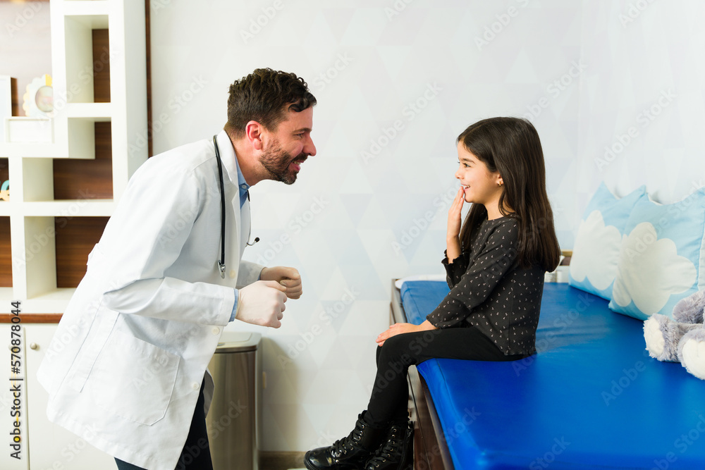 Obraz premium Cheerful doctor having fun with a kid patient