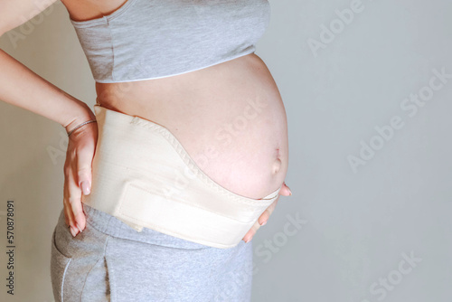 Pregnant woman belly in prenatal pregnancy maternity belt. Orthopedic abdominal support waist, back, abdomen band. Belly brace or band for pregnancy