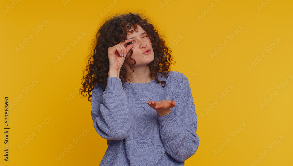 Need some more, please give me. Curly haired woman showing a little bit gesture with sceptic smile, showing minimum sign, measuring small size. Young girl isolated alone on yellow studio background Need some more, please give me. Curly haired woman showing a little bit gesture with sceptic smile, showing minimum sign, measuring small size. Young girl isolated alone on yellow studio background