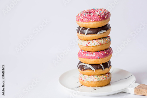 Delicious dessert. Pink, white and chocolate donuts with multicolored sprinkles on a white background of Sweets. Confectionery products.
