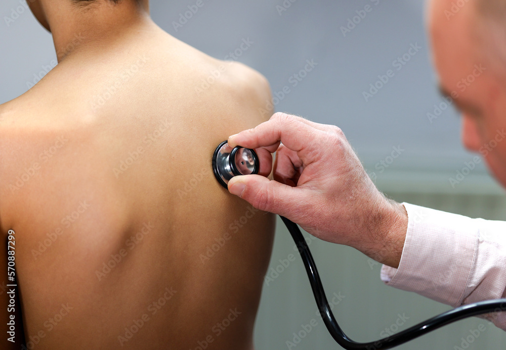 Fototapeta premium Closeup hand of Caucasian male pediatrician use stethoscope do pediatric checkup examination on child boy patient from back to check heart lungs, children medical care concept. 