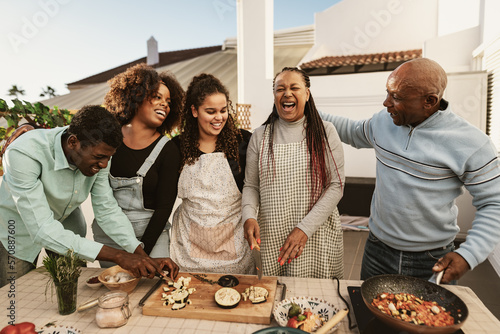 Photos Happy African family preparing food recipe together on house patio