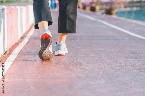 sport, exercise concept. runner woman wearing sports shoes for running, jogging on running track in stadium morning. people exercise of healthy and lifestyle. exercise outdoor in nature park in summer