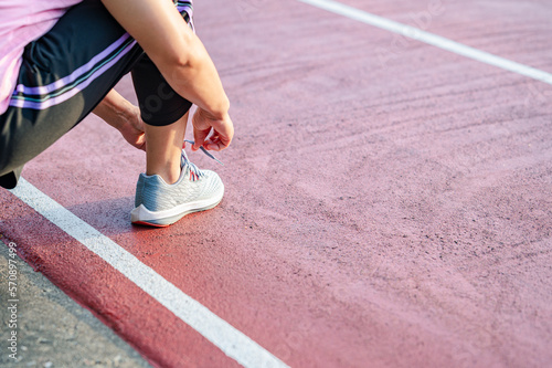 sport, exercise concept. runner woman wearing sports shoes for running, jogging on running track in stadium morning. people exercise of healthy and lifestyle. exercise outdoor in nature park in summer