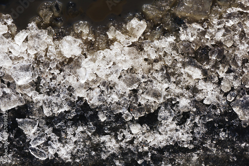 Snow background. Ice texture. Winter seanson pattern. Pile of snow. Crystal snowflake shine. Frozen puddle. Small pieces of ice. Cracked water freeze. photo