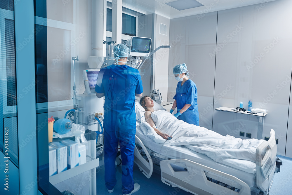 Nurses in intensive care unit of hospital checking vitals of