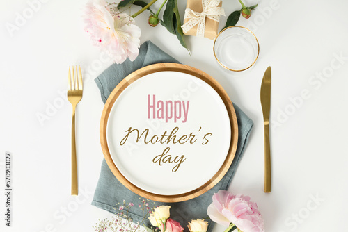 Happy Mother's day concept. Beautiful table setting with golden cutlery and peony flowers