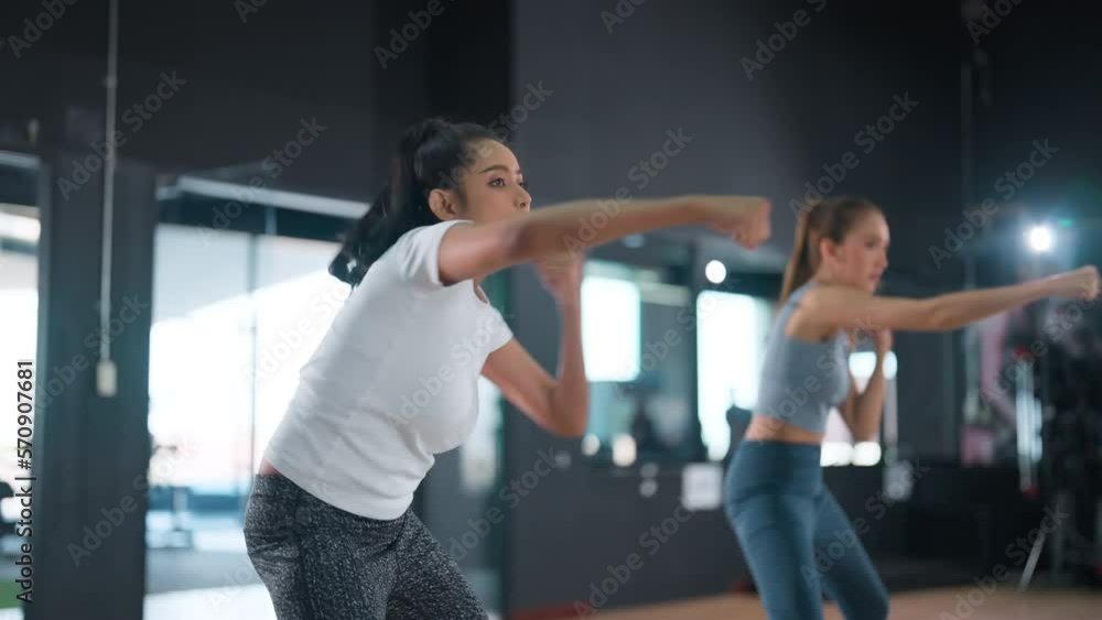 young women friend doing boxing punches body combat crossfit during fitness martial arts workout in training class. Male instructor showing exercise at fitness gym young women friend doing boxing punches body combat crossfit during fitness martial arts workout in training class. Male instructor showing exercise at fitness gym
