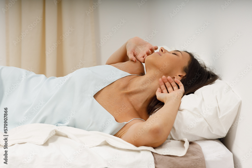 Healthy young woman dressing nightie lying on bed in bedroom. Healthy young woman dressing nightie lying on bed in bedroom.