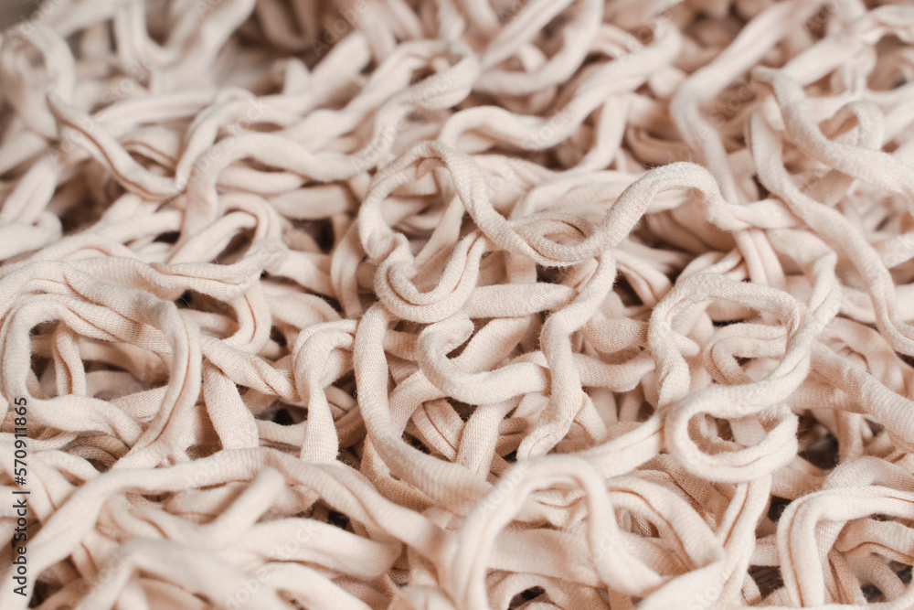 Tangled beige threads yarn noodles texture background