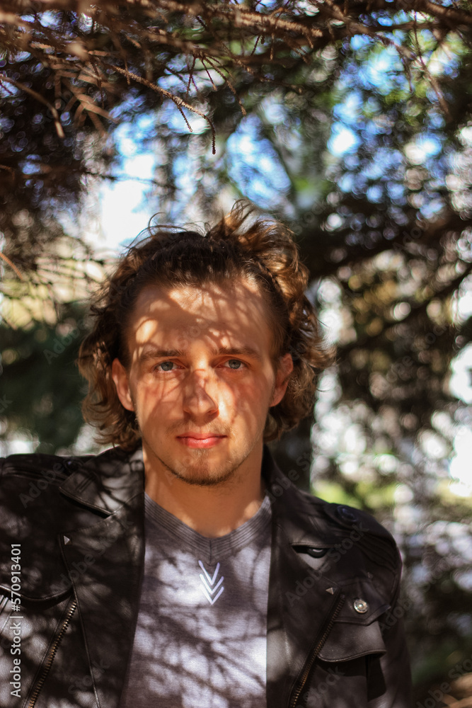 young man in the shade of tree branches young man in the shade of tree branches