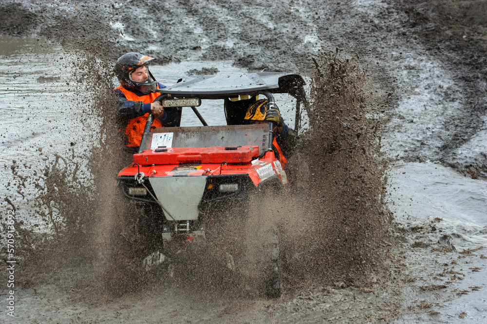athlete on a ssv rides in the mud
