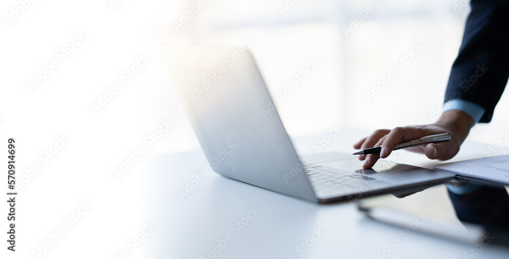 Close up view of businessman hand using and typing on laptop computer in bright modern office room. Close up view of businessman hand using and typing on laptop computer in bright modern office room.
