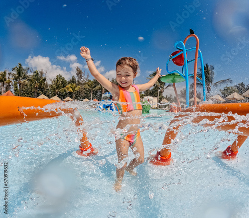 Little girl enjoying water amusement park at family vacation.