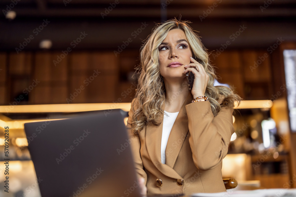 Young businesswoman using laptop while working in a modern coffee shop Young businesswoman using laptop while working in a modern coffee shop