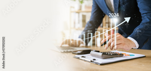 businessman new year business goals 2024, positive indicators 2024, company competitiveness on global scale, businessman calculating financial data for long term investments.