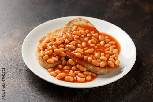Cuadro en lienzo Baked beans on toast in tomato sauce on white plate